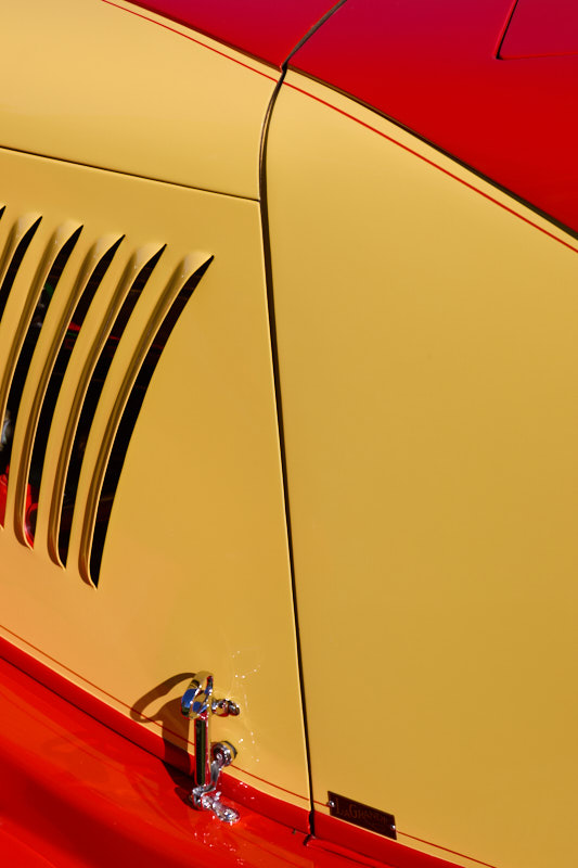 Louvred side vents on cream bodywork above a red lower panel