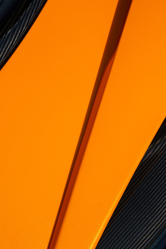 Orange painted panel flanked by exposed carbon fibre