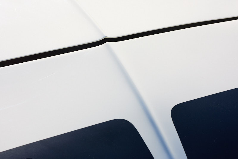 Panel creases and shutlines across white bodywork