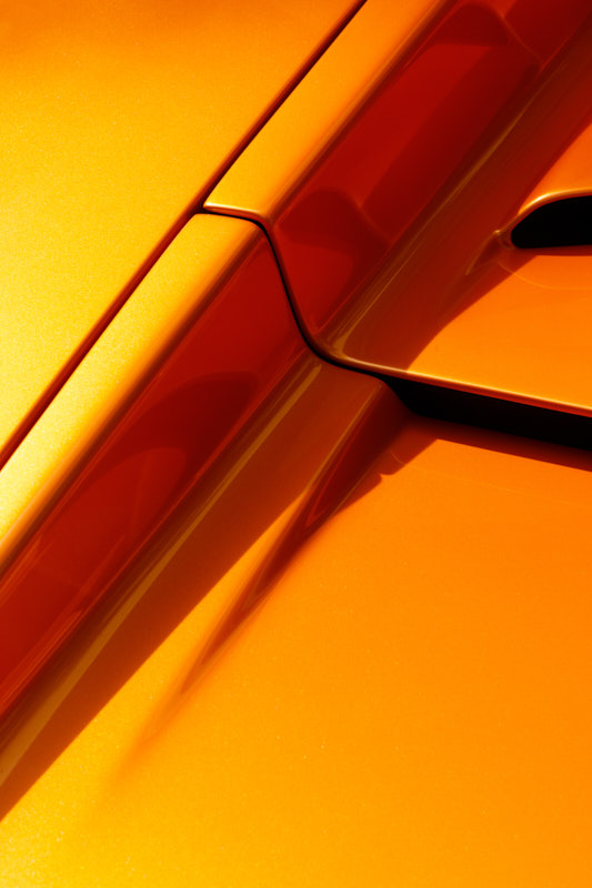 Shutline and door handle catching light on orange bodywork