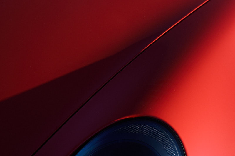 Shutline and wheel arch across deep red bodywork in low light